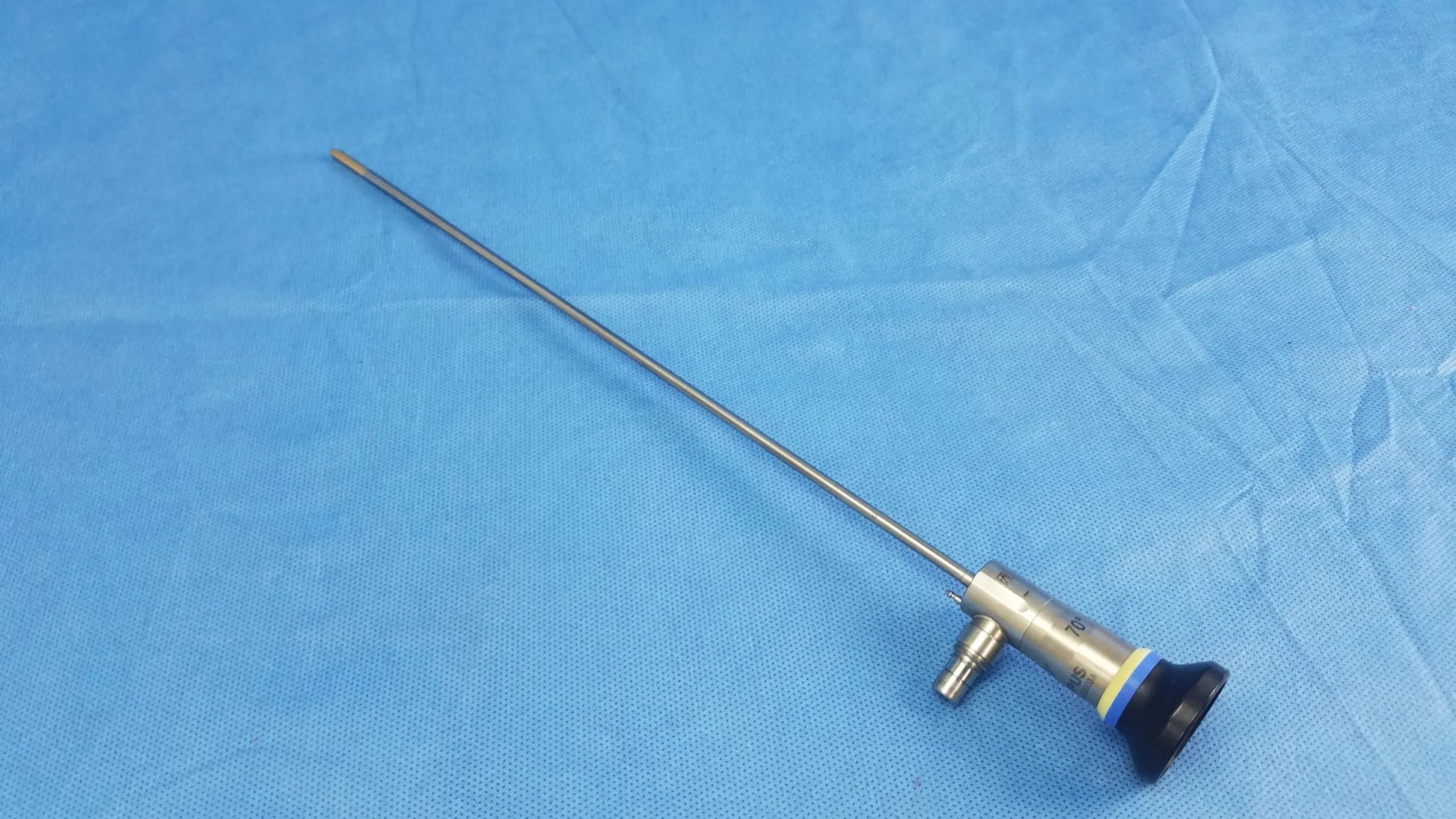 Silver rigid scope with black and blue handle and long metallic shaft compatible with Olympus endoscopic systems