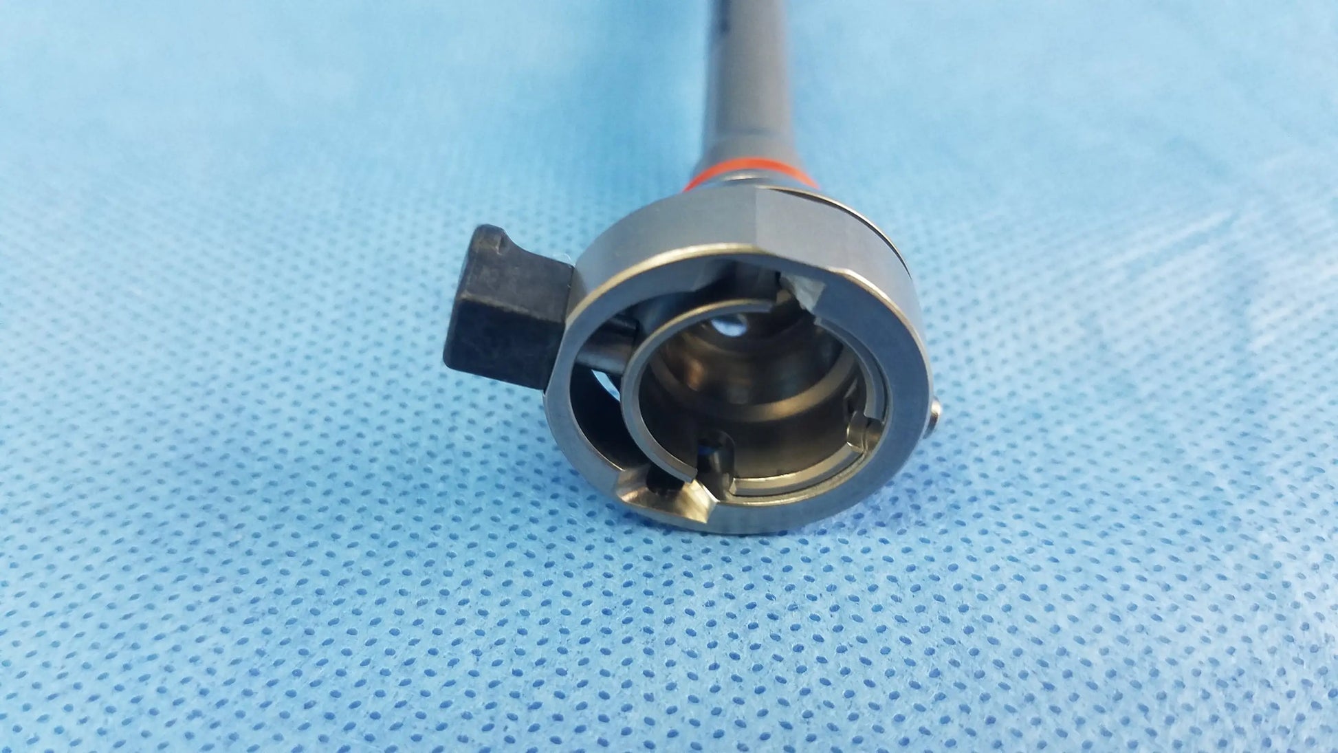 Olympus A22042A resection sheath with silver surgical instrument and black handle featuring orange band endoscopic instrument component