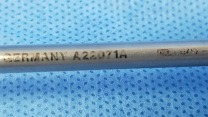 A metallic olympus a22071a visual optical obturator with engraved markings on a blue perforated surface