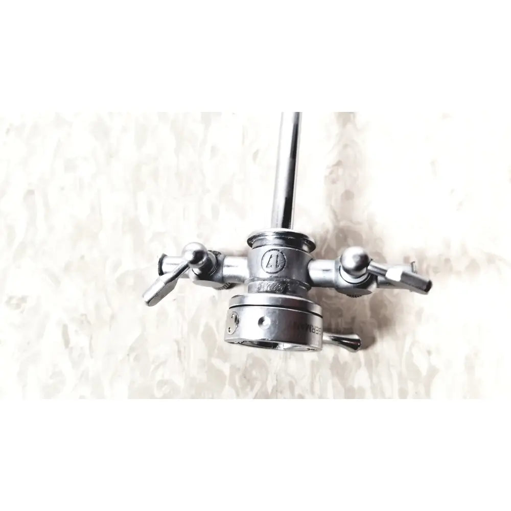 Silver surgical instrument with central shaft and four articulated arms in olympus a2211 dual valve sheath 17 fr instrument