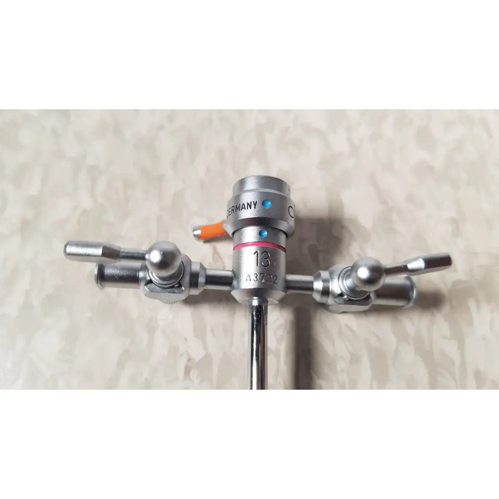 Silver surgical instrument with three articulated arms and an orange germany knob of olympus a3722 pediatric sheath