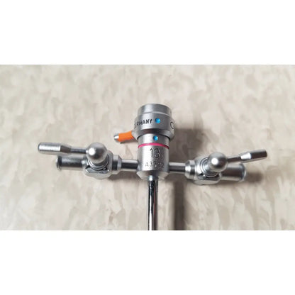 Silver surgical instrument with three articulated arms and an orange germany knob of olympus a3722 pediatric sheath