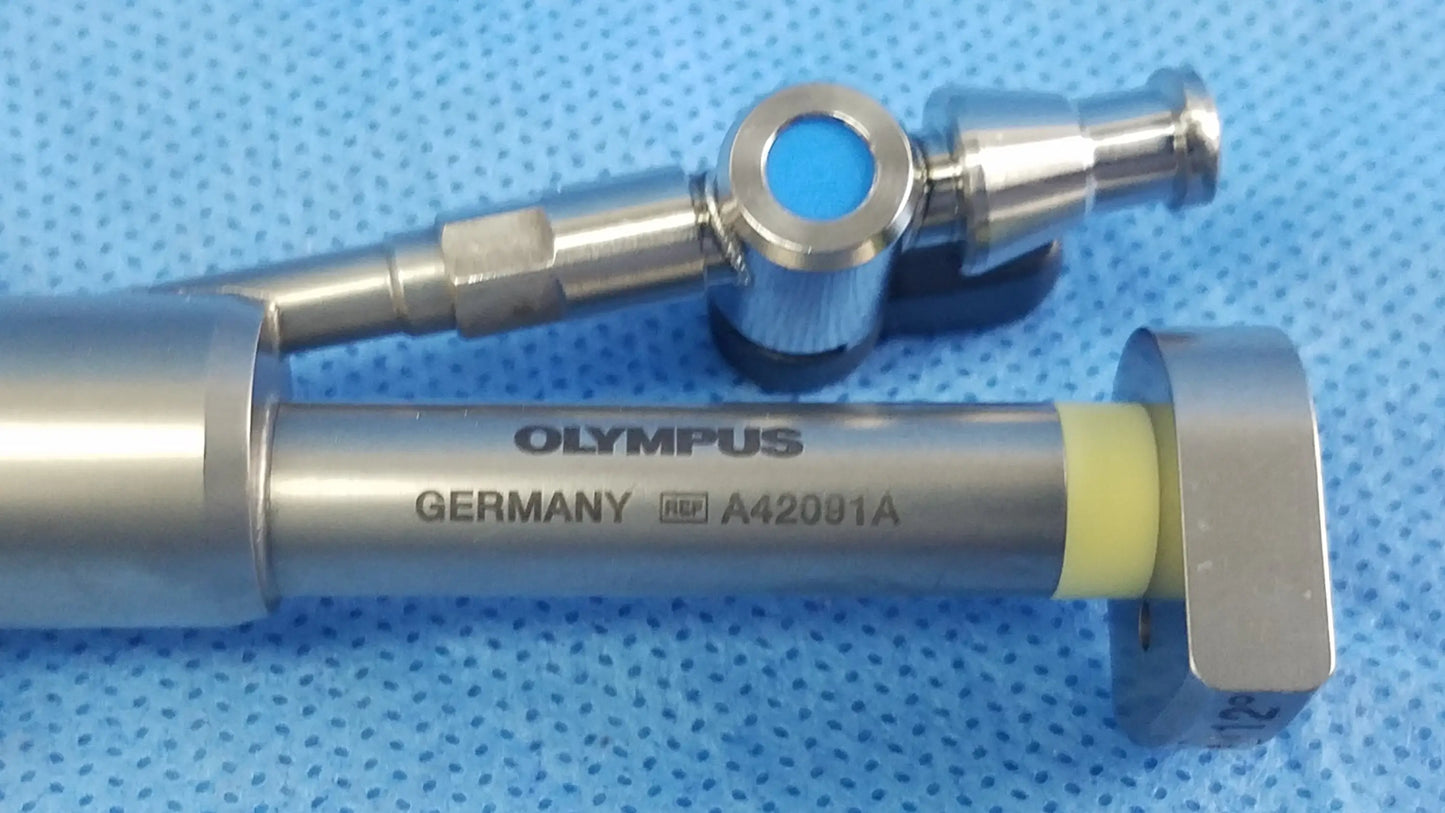 Silver metallic olympus a42091a working insert with blue circular component and yellow seal in sterilization tray