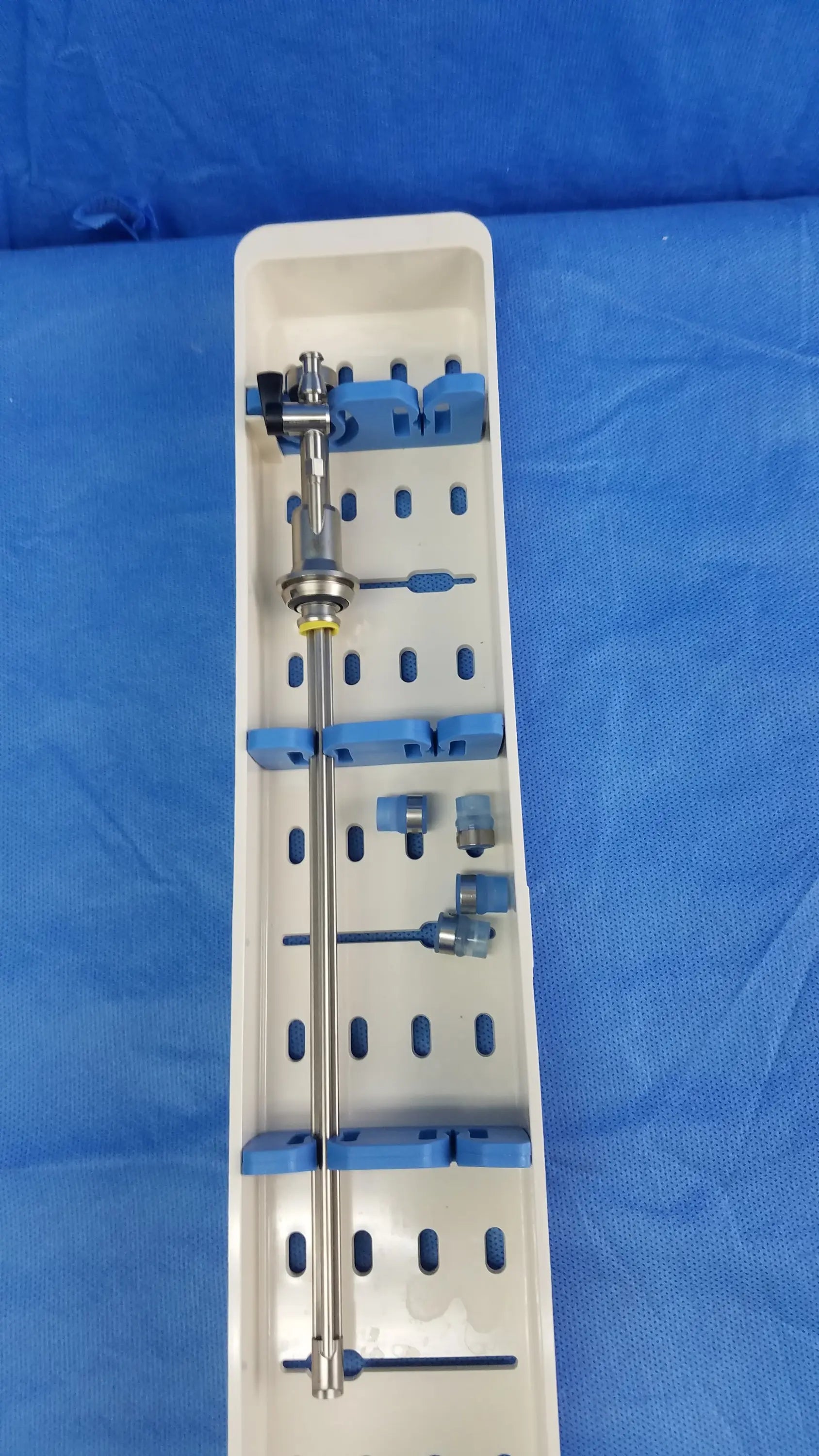 Silver surgical instrument set with blue gyrus acmi silicone seals arranged in white sterilization tray for working insert