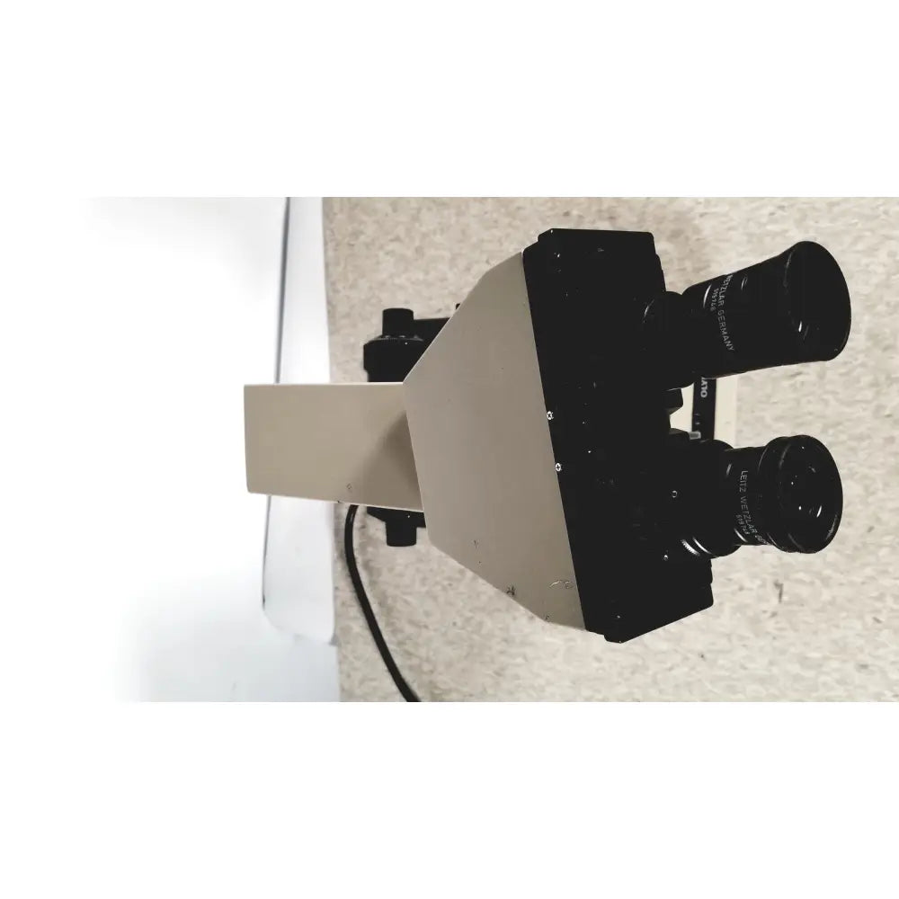 Black and beige olympus bh-2 binocular microscope with dual eyepieces labeled leica germany on the lenses