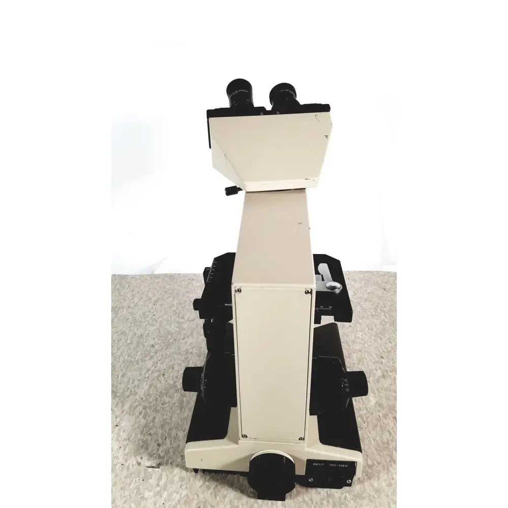 Beige and black olympus bh-2 binocular microscope with dual eyepieces and adjustable stage for compound microscopy