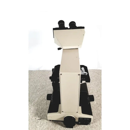 Beige and black olympus bh-2 binocular microscope with dual eyepieces and adjustable stage for compound microscopy