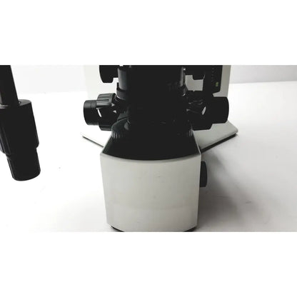 Black and white olympus bx51tf microscope with adjustable lenses and sturdy base showing some damage on body working condition
