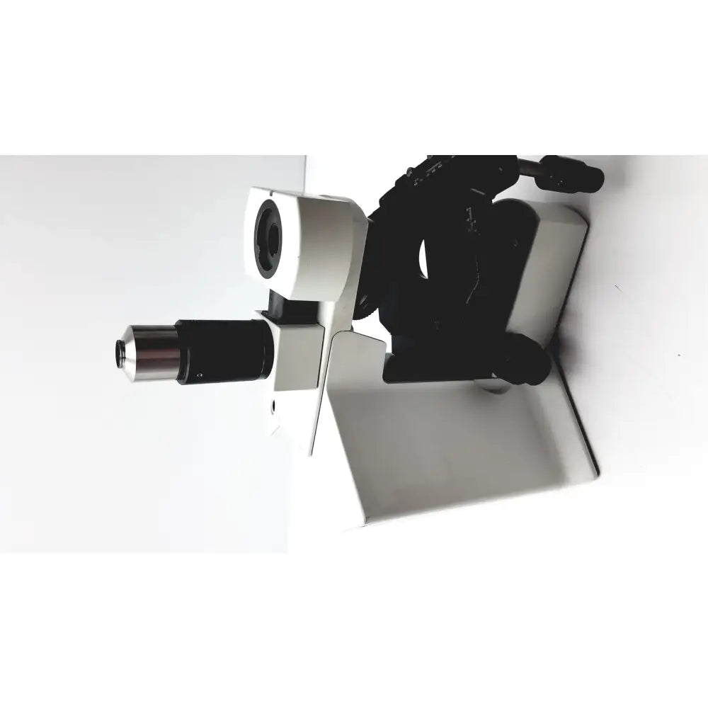 A sleek white and black olympus bx51tf microscope with metallic accents and some damage on the body, fully functional
