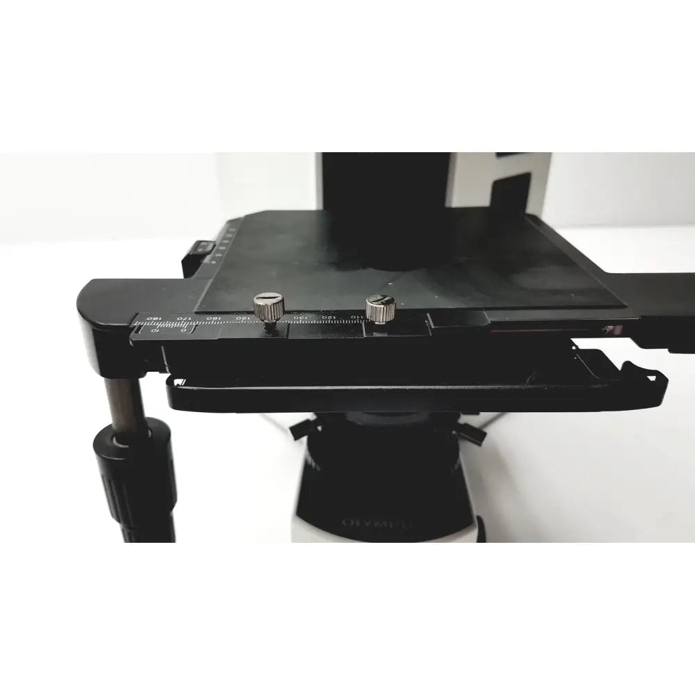Black matte-finish microscope stage with adjustable knobs and measurement markings on olympus bx51tf microscope body with damage