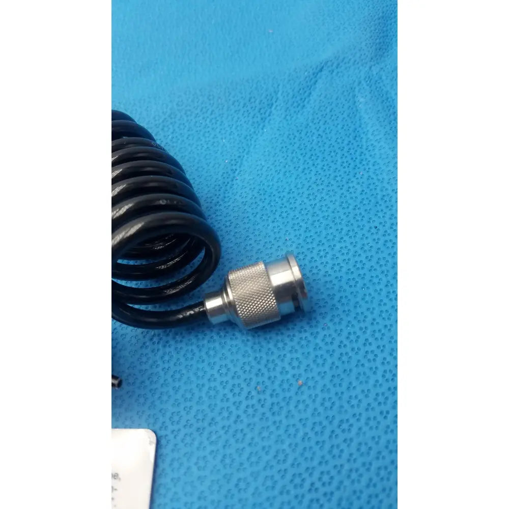 Black coiled cable with silver knurled metallic connector for olympus endoscope leakage tester device