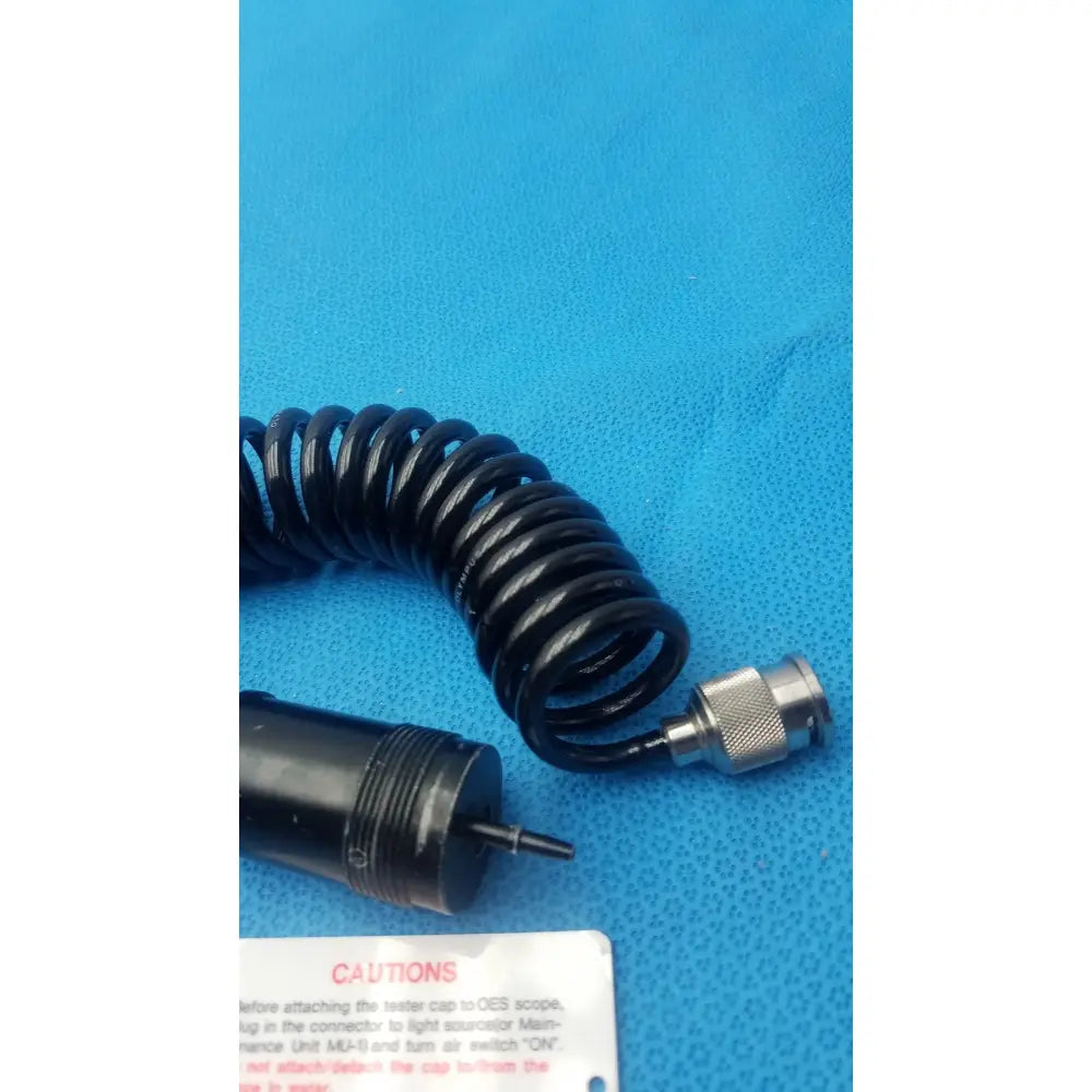 Black coiled cable with metallic connector end for olympus endoscope leakage tester used in endoscope leakage detection