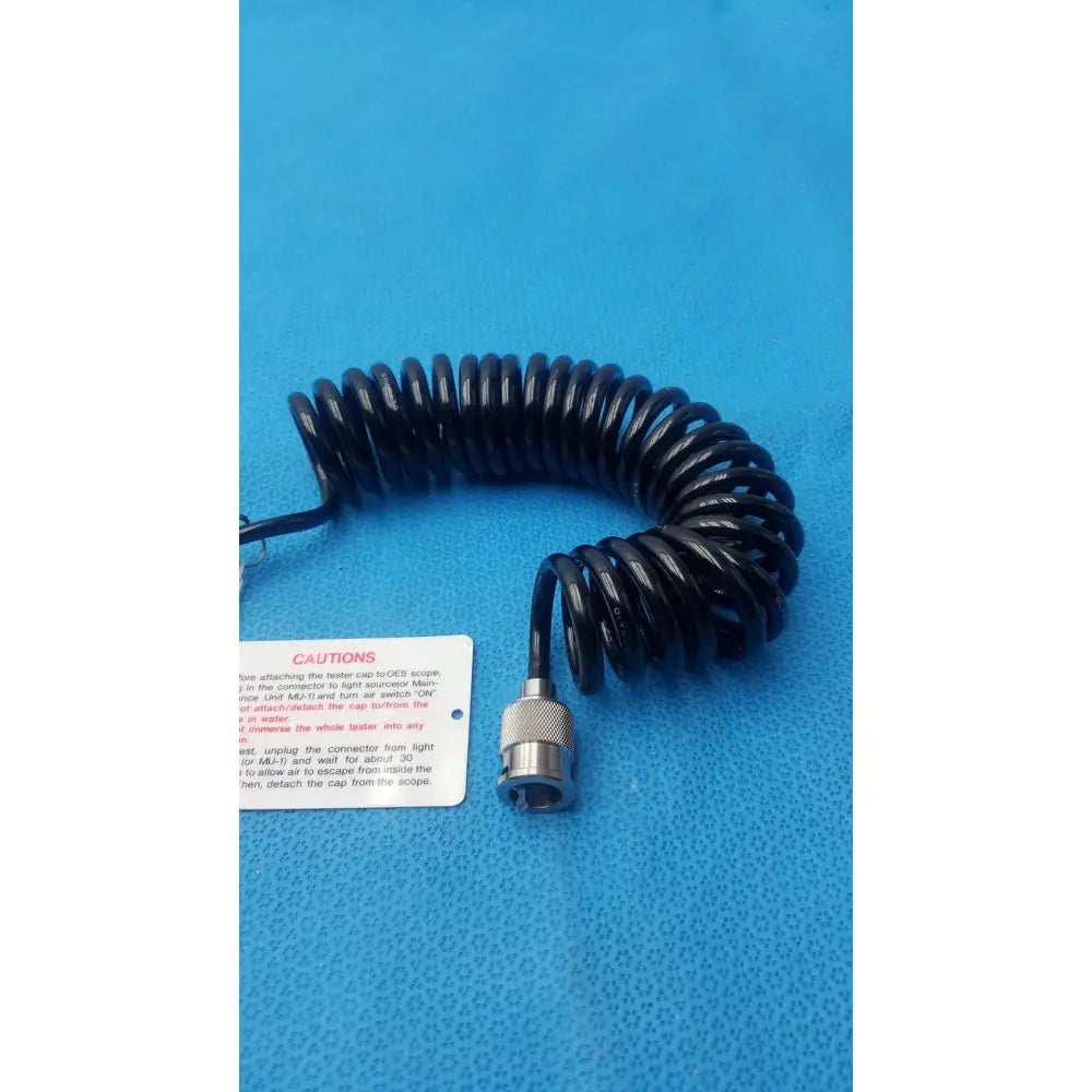 Black coiled cable with metallic connector end for Olympus endoscope leakage tester ensuring accurate endoscope leakage detection