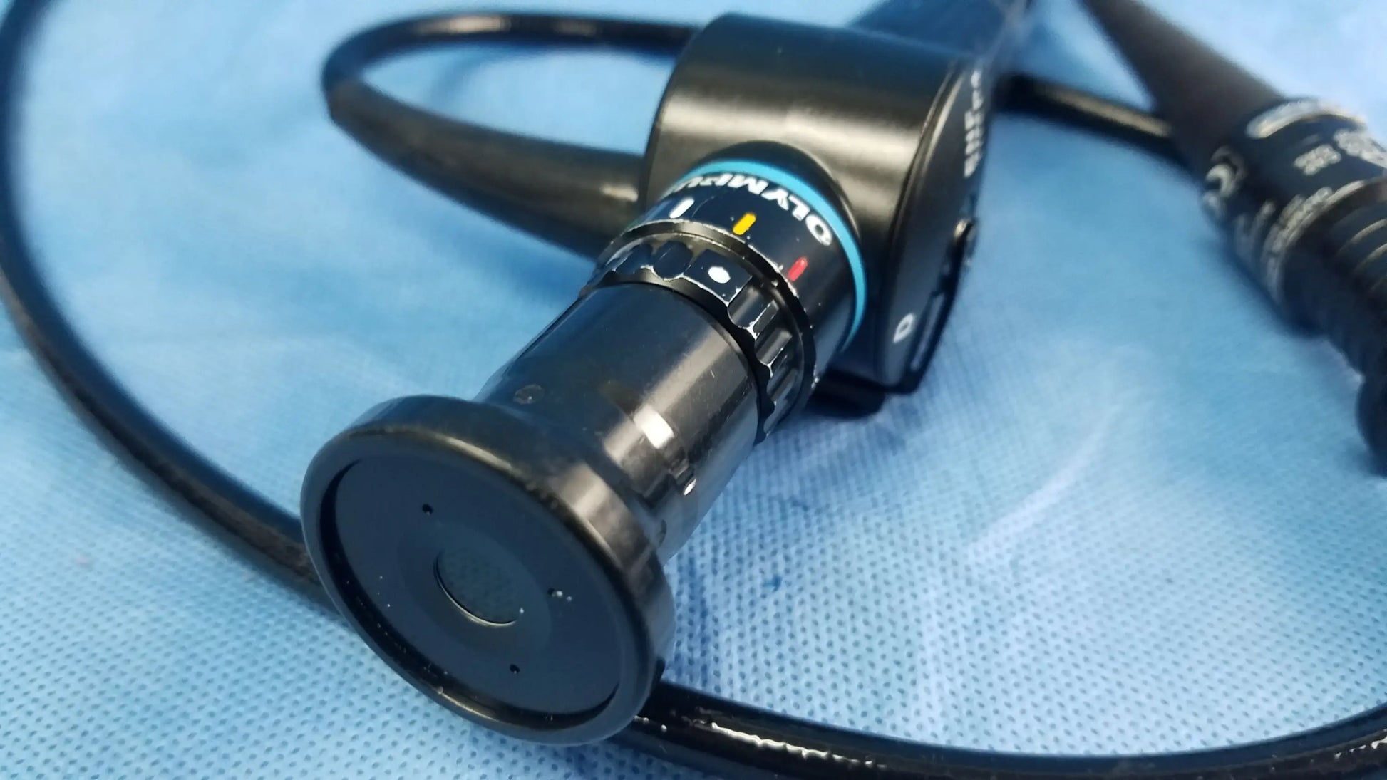 Black Olympus endoscope rhino-laryngoscope fiberscope with sleek cylindrical body and blue-accented flexible fiber optic ring
