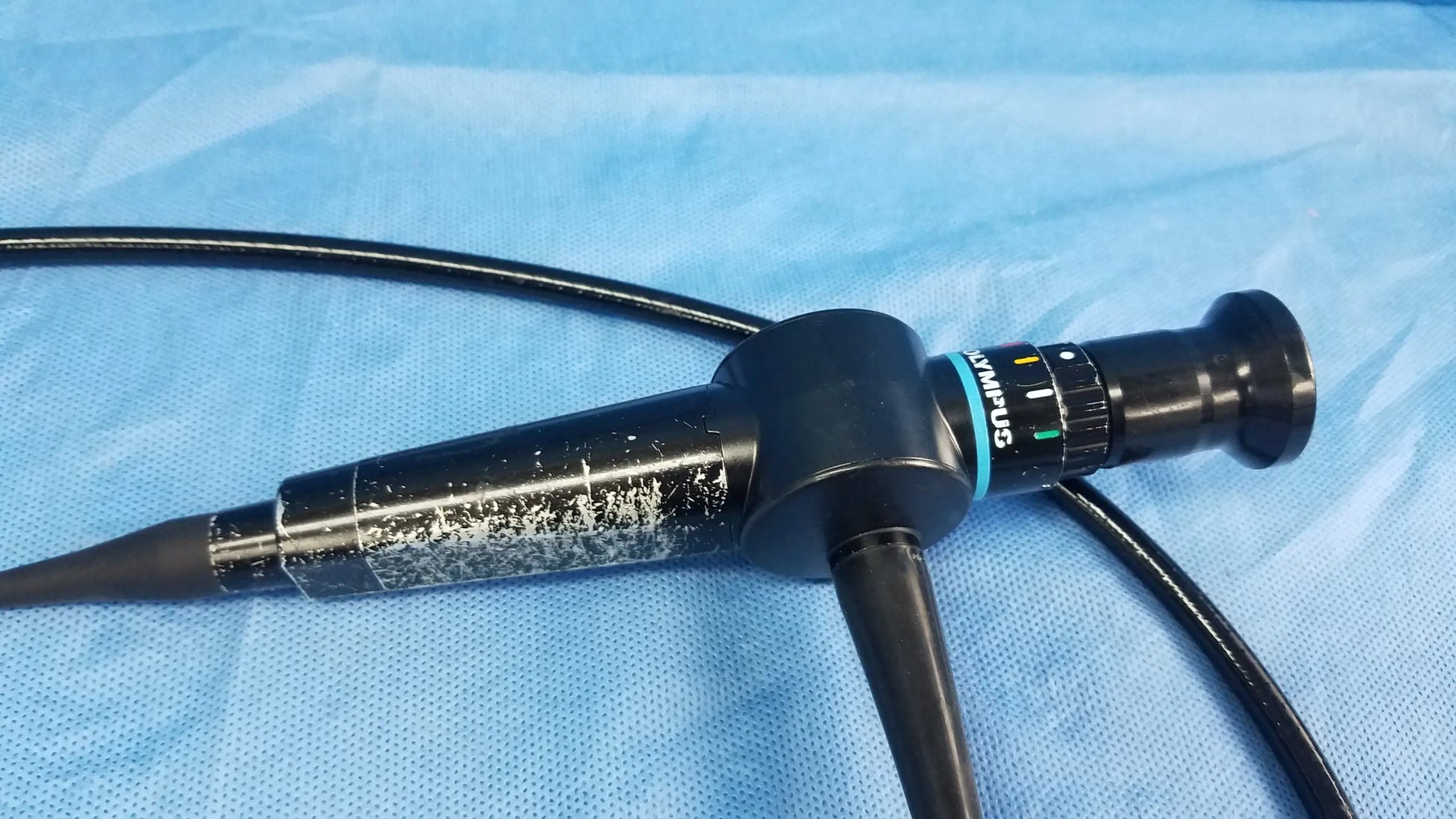Black olympus endoscope rhino-laryngoscope fiberscope with textured grip and blue accent ring flexible fiber optic design