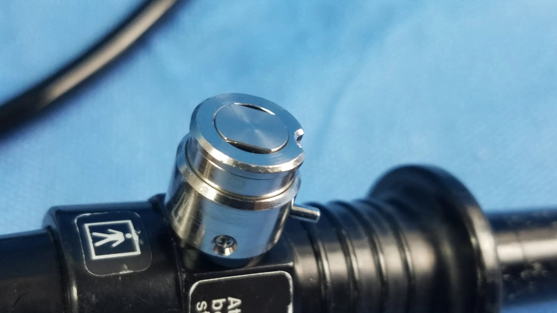 Silver metallic control knob with ridged sides on black cylindrical flexible fiber optic endoscope device olympus enf-p4