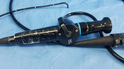 Black Olympus fiber optic endoscope rhino-laryngoscope type ENF-P4 with textured grip and labeled controls on blue drapes