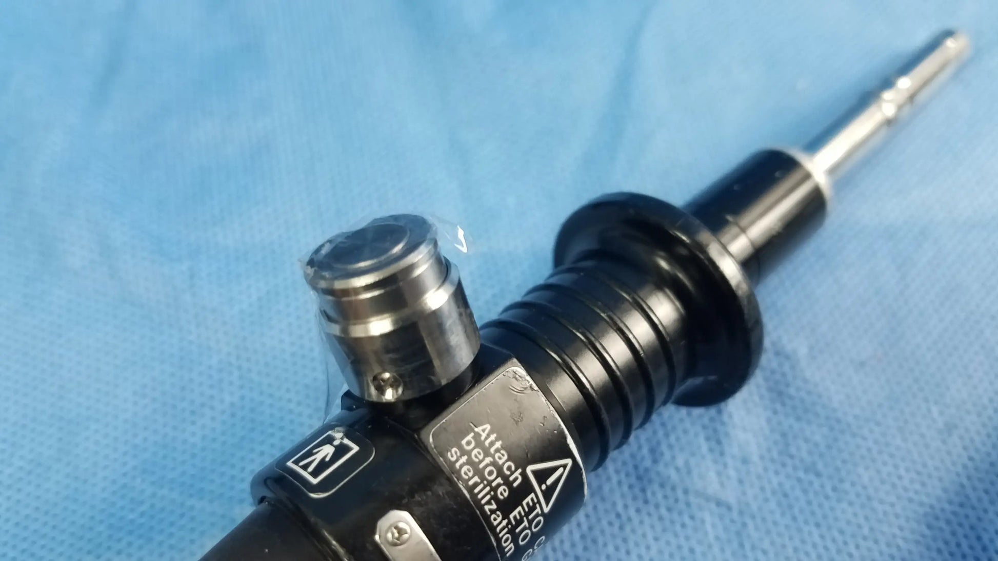Black and silver Olympus fiber optic flexible endoscope rhino-laryngoscope with textured grip labeled attach before sterilization
