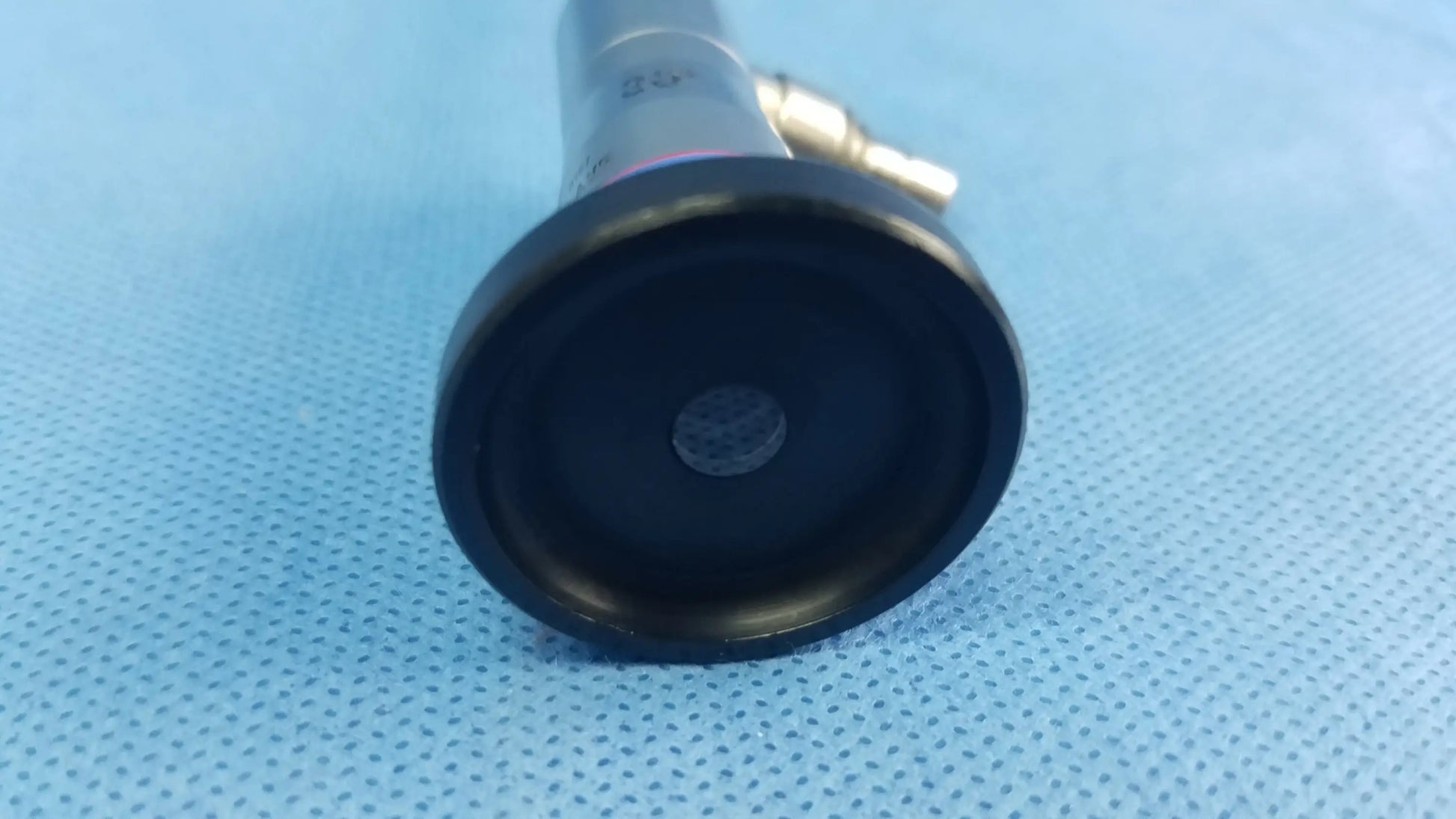 Black rubberized end cap with metallic connector on the back side of a compatible olympus cystoscopic a22002a autoclave cystoscope
