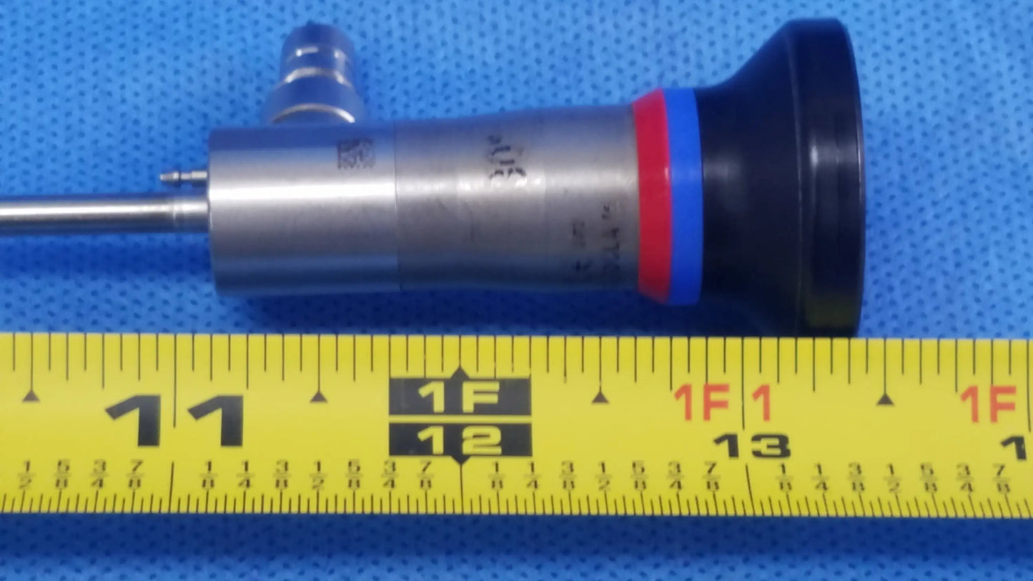 Silver and black a22002a autoclave cystoscope with red and blue bands resting on yellow measuring tape compatible olympus cystoscopic