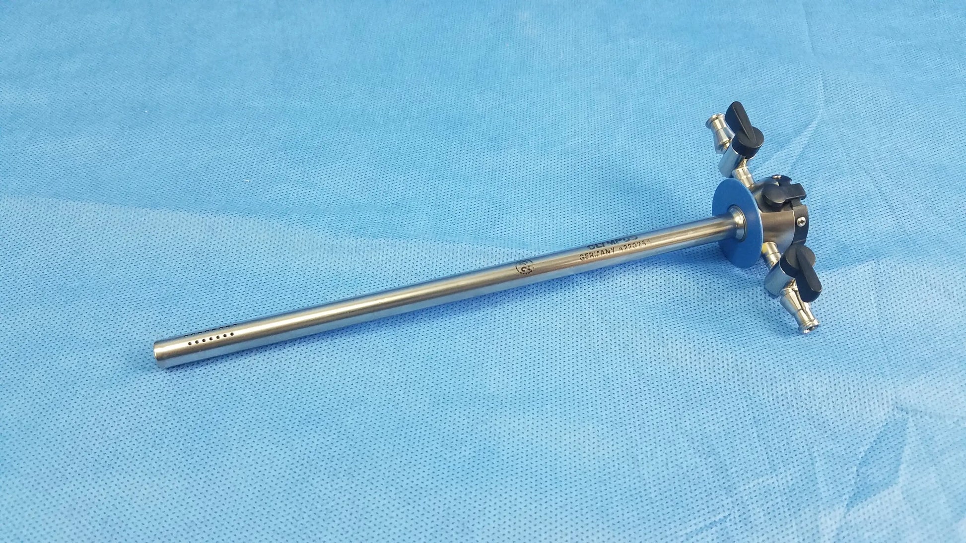 Silver continuous-flow outer resectoscope sheath with black-handled adjustment knobs and blue-tinted head by Olympus Germany