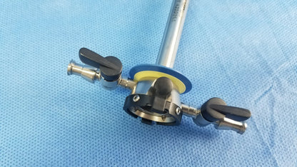 Silver surgical instrument with black handles and a blue circular component for Olympus continuous-flow outer resectoscope sheath