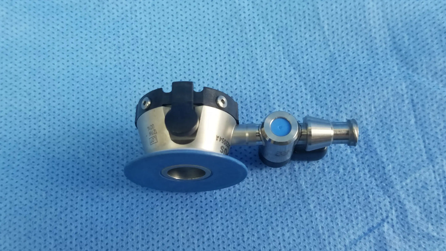 Silver surgical endoscope irrigation port with black and blue accents and circular base plate compatible olympus endoscopic instrument component