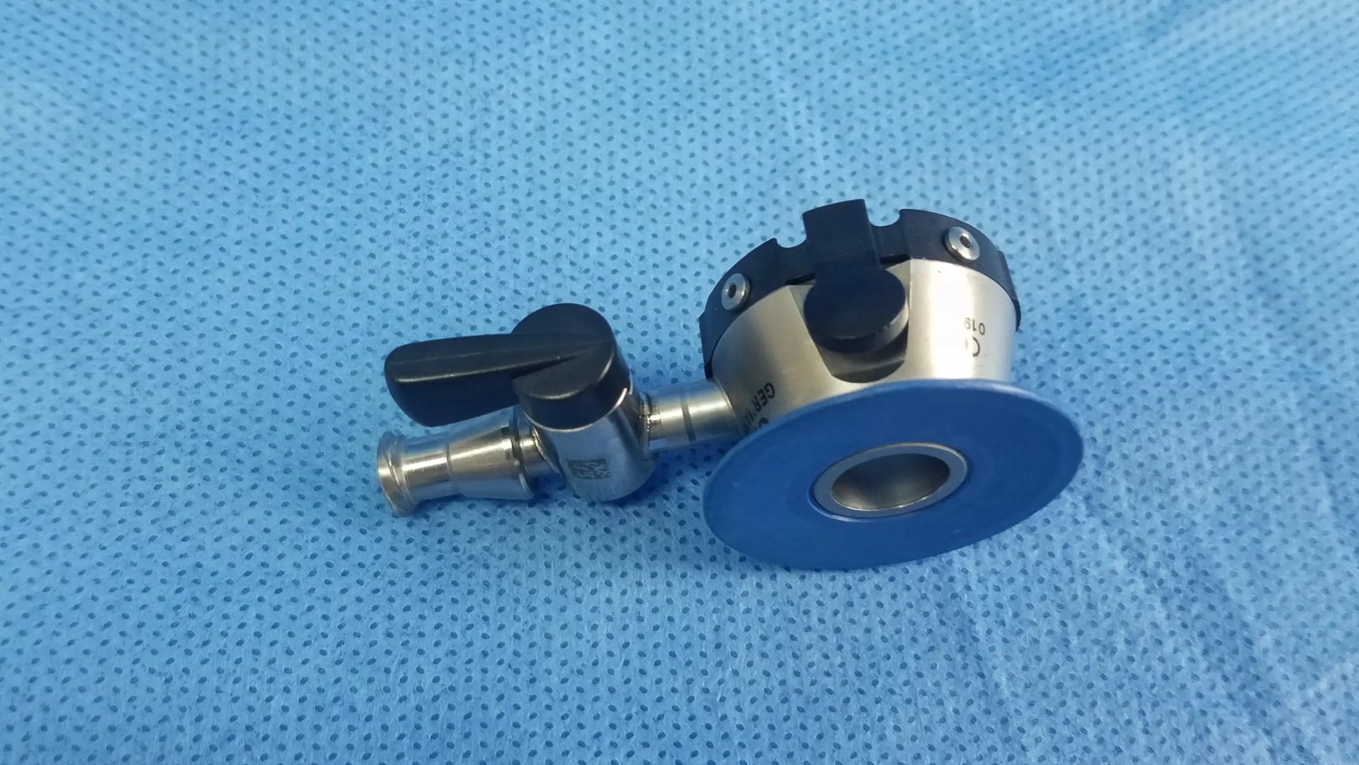 Silver surgical irrigation port with black handle and blue circular base compatible olympus endoscopic instrument component