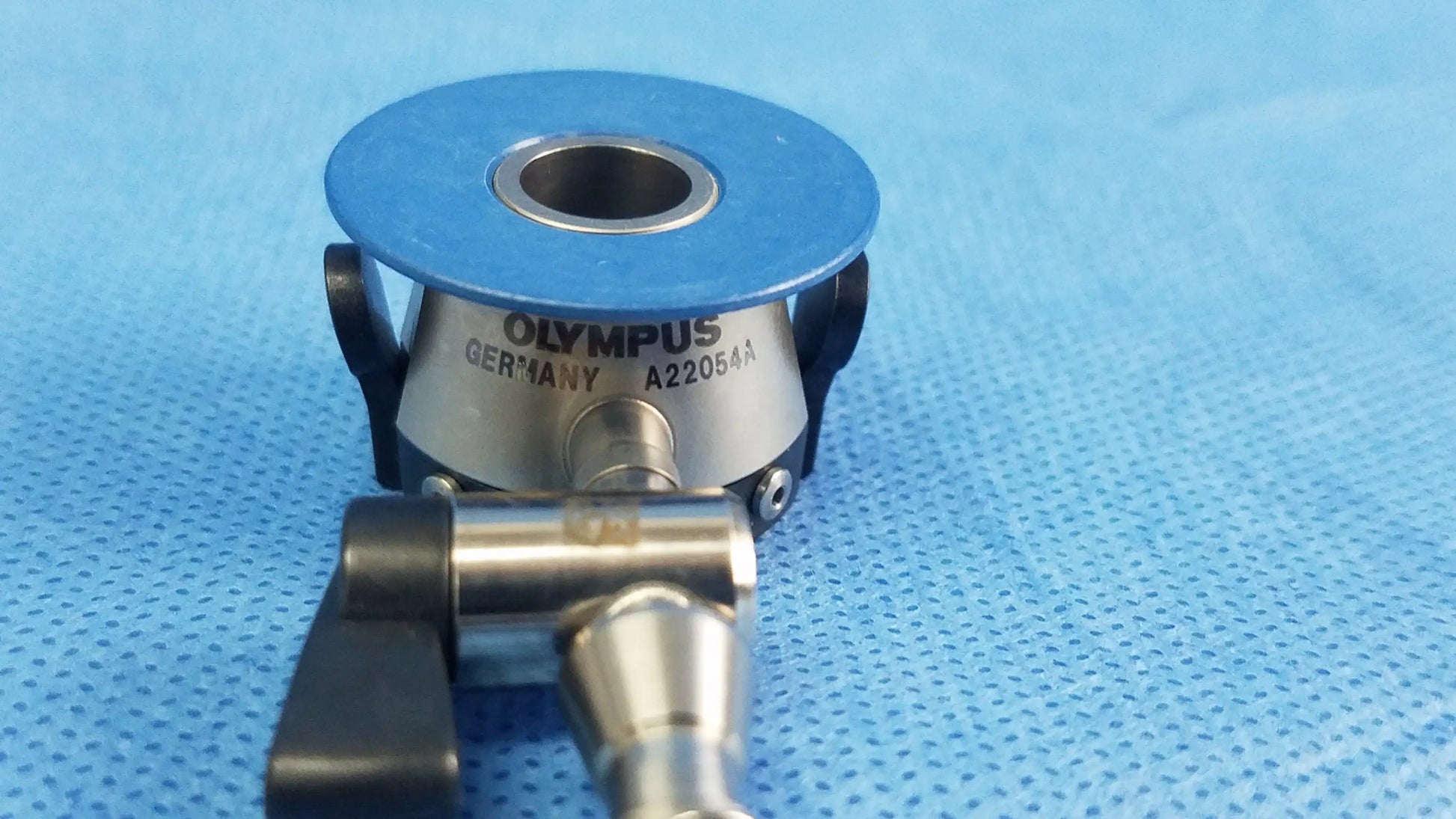 Olympus Germany A22054A irrigation port with a blue circular top and metallic body compatible with endoscopic instruments