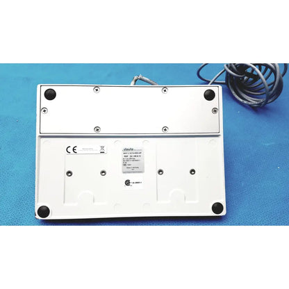White plastic olympus maj-1258 ues-40 pedal foot switch base with black rubber feet and coiled gray cable at back side