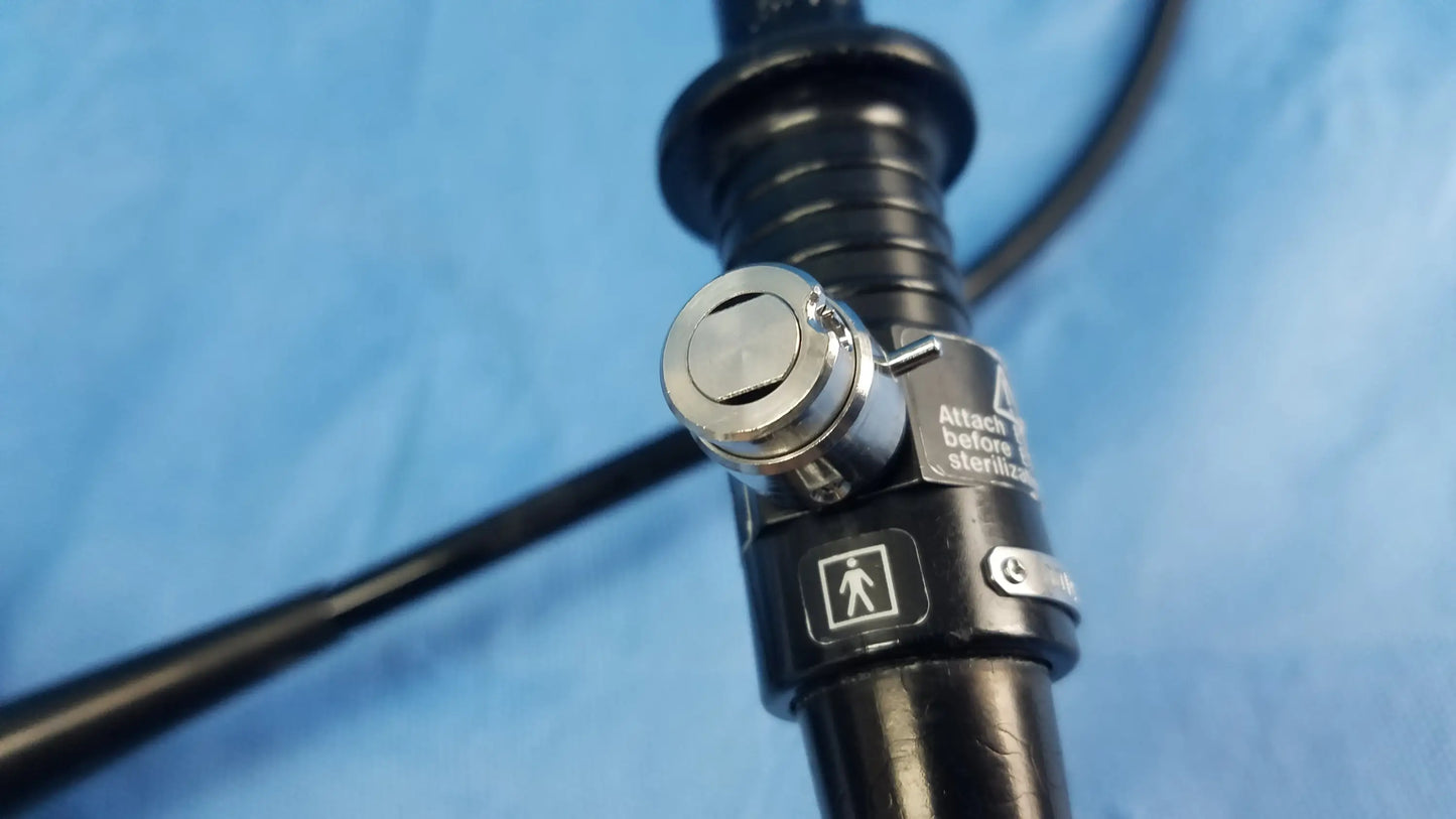 Black flexible fiber optic endoscope with silver locking mechanism and labeled stickers by Olympus Medical Systems