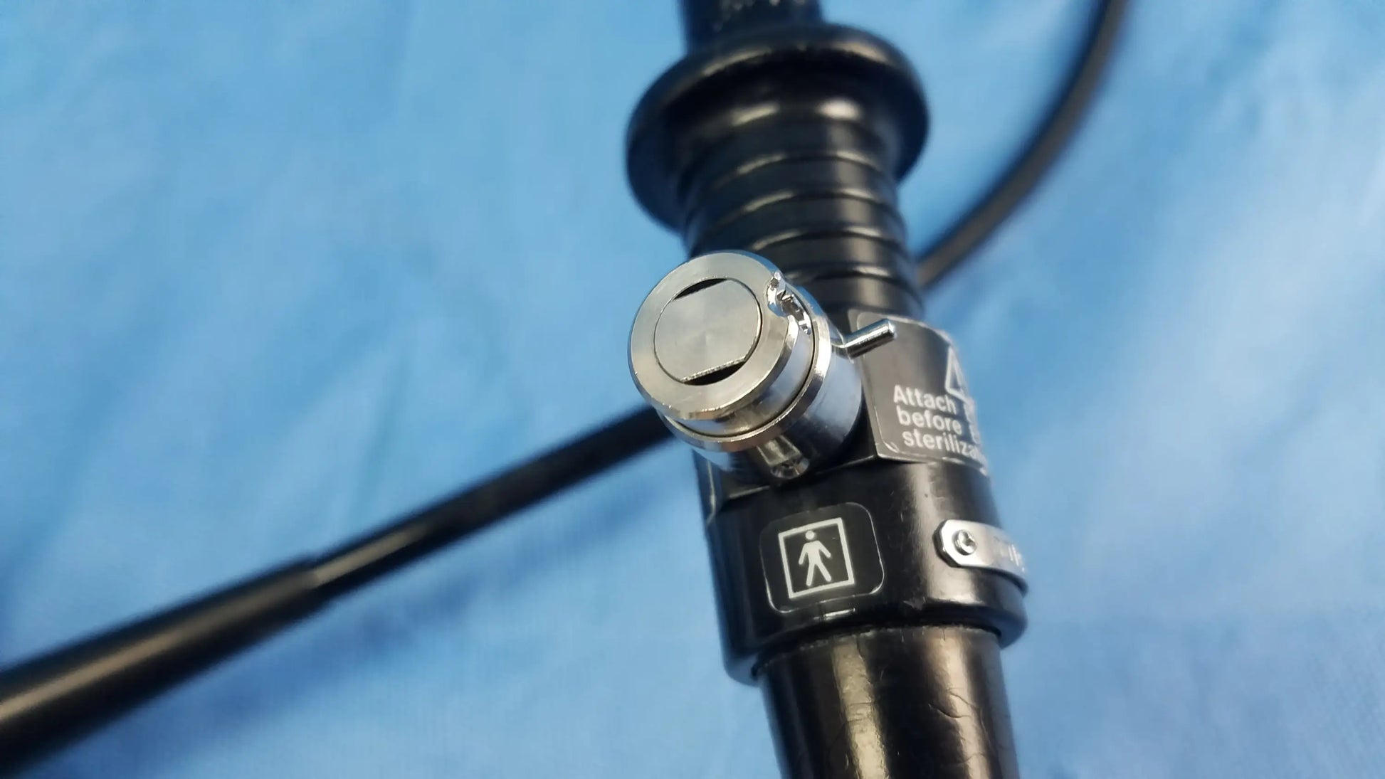 Black flexible fiber optic endoscope with silver locking mechanism and labeled stickers by Olympus Medical Systems