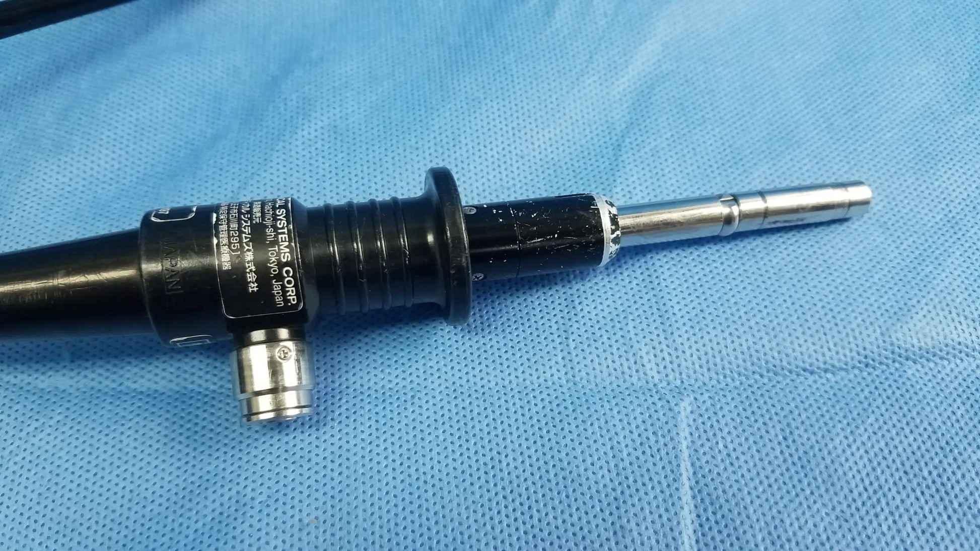 Black and silver flexible fiber optic endoscope with textured grip and metallic tip by Olympus Medical Systems