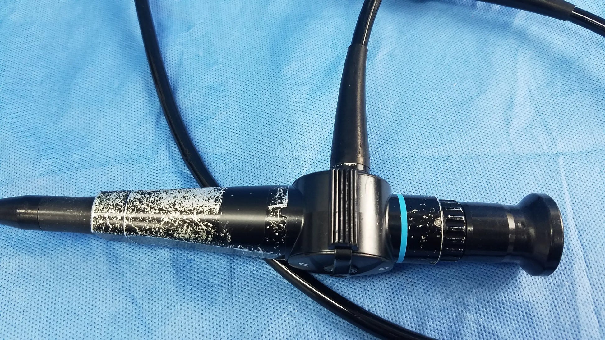 Black flexible fiber optic endoscope with textured grip and blue accent ring by Olympus Medical Systems ENF-P4 Rhino-Laryngoscope