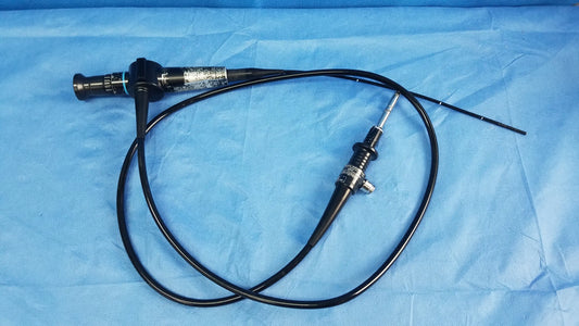 Black flexible fiber optic endoscope with metallic tip and control knobs on blue drapes from Olympus Medical Systems