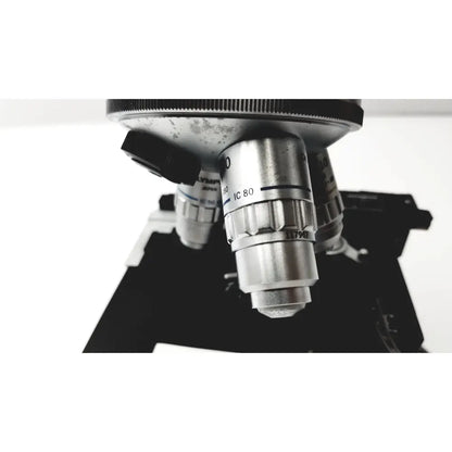 Silver metallic microscope objective lens with engraved markings and black adjustment knob for olympus optical bh2-uma microscope