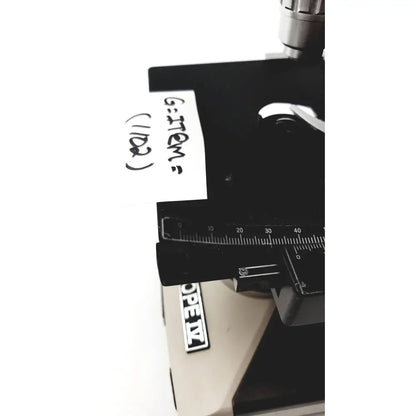 Black microscope stage with ruler and handwritten label on olympus optical bh2-uma microscope product