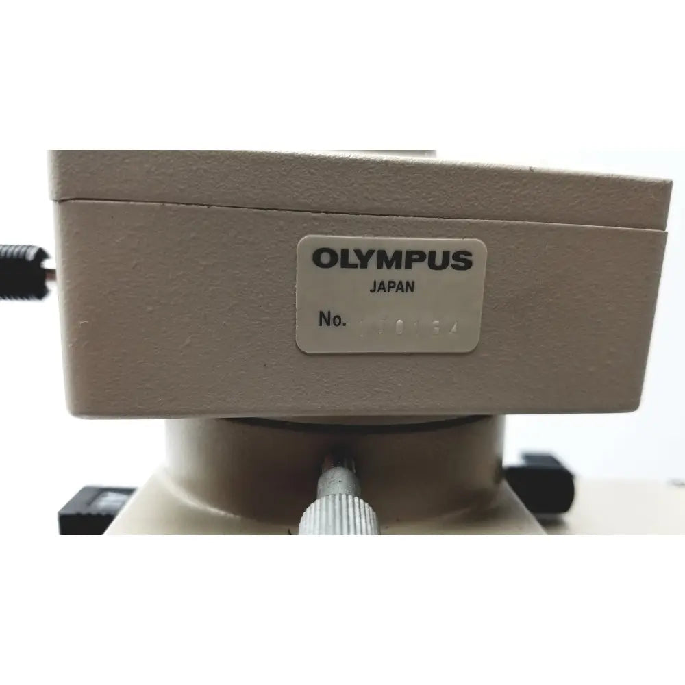 Beige olympus optical bh2-uma microscope base with a silver label showing brand name and serial number