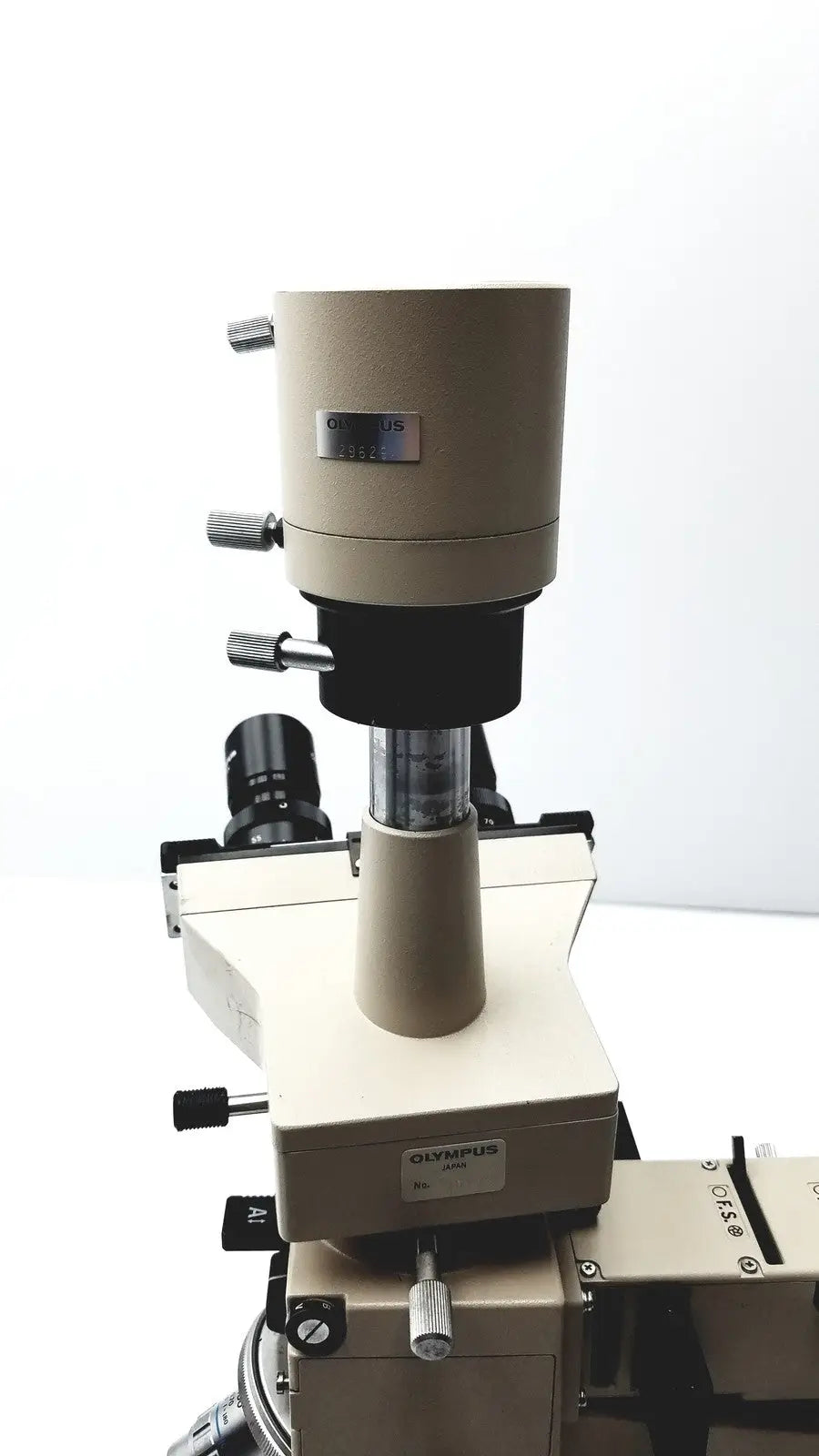 Beige Olympus optical BH2-UMA microscope with black optical components and metallic adjustment knobs for precision use