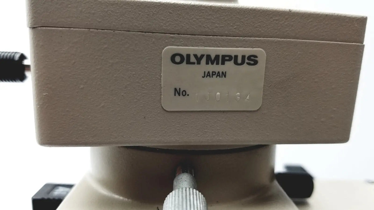 Beige olympus optical bh2-uma microscope base with a silver label showing brand name and serial number
