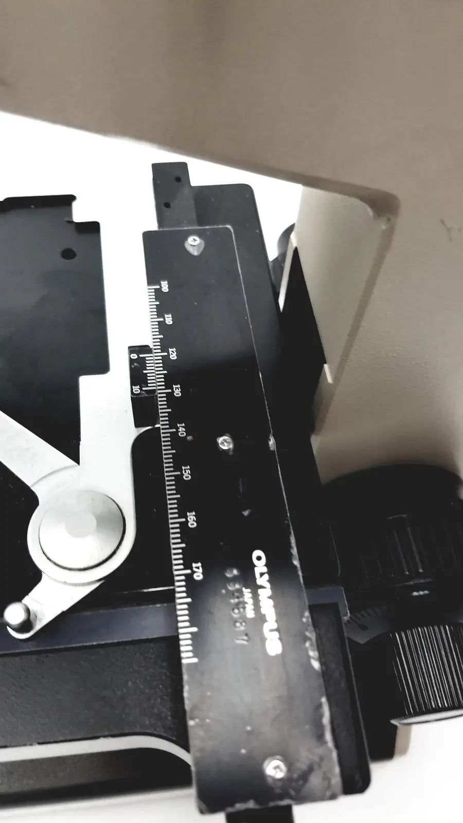 Black Olympus Optical BH2-UMA microscope ruler with white markings and silver screws for precision measurement