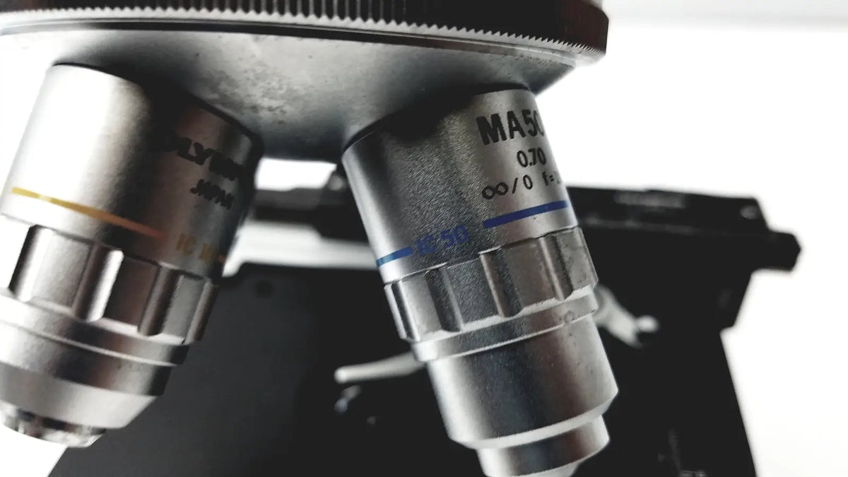 Silver metallic microscope objective lenses with engraved markings and blue lines for olympus optical bh2-uma microscope