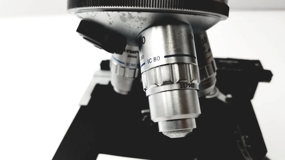 Silver metallic microscope objective lens with engraved markings and black adjustment knob for olympus optical bh2-uma microscope