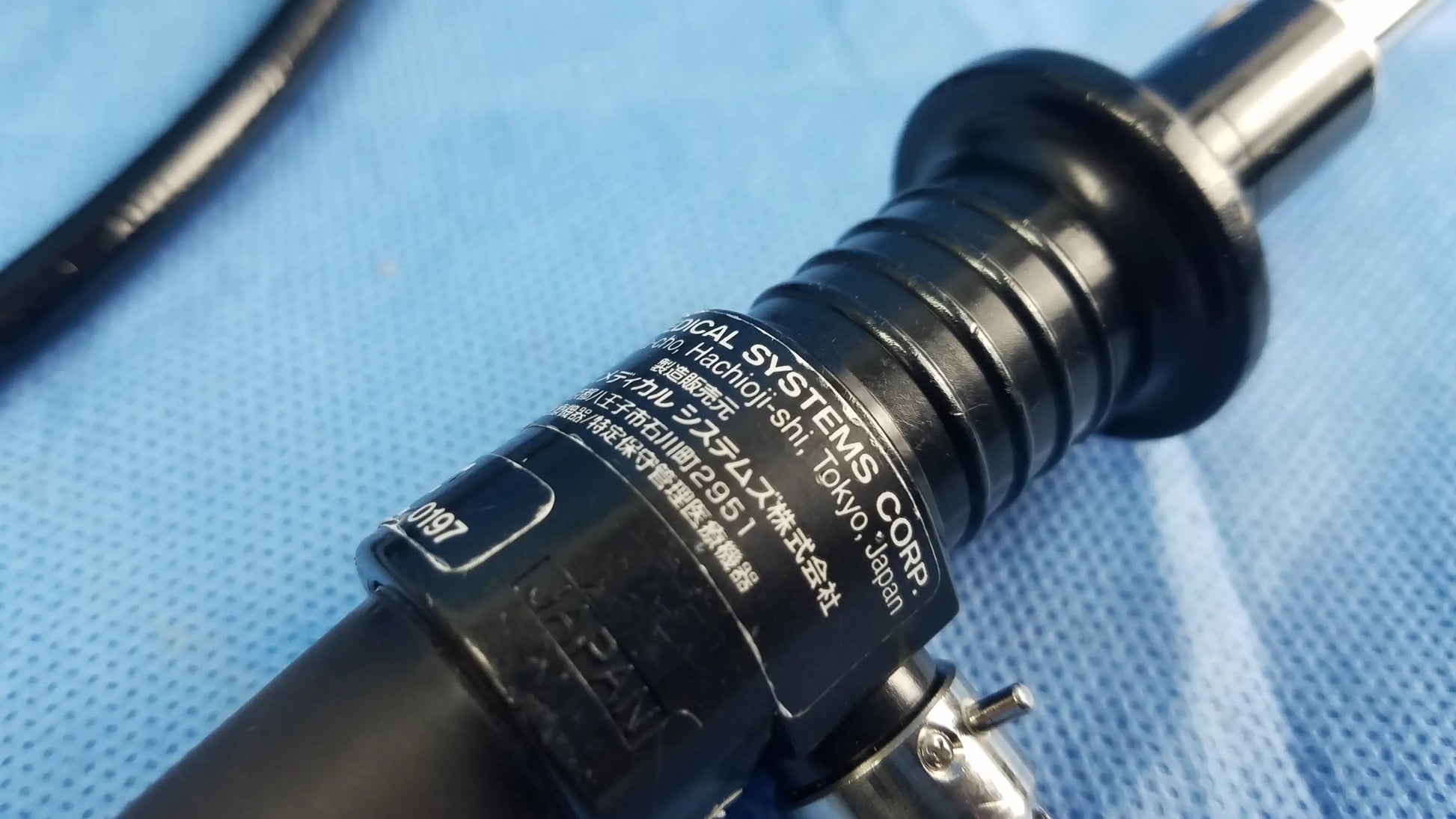 Black fiber optic endoscope with ribbed barrel and metallic tip engraved olympus systems corp rhino laryngoscope enf-p4 fiber optic