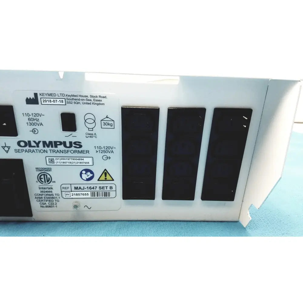 White Olympus separation transformer with black panels and label showing technical specifications and certification marks
