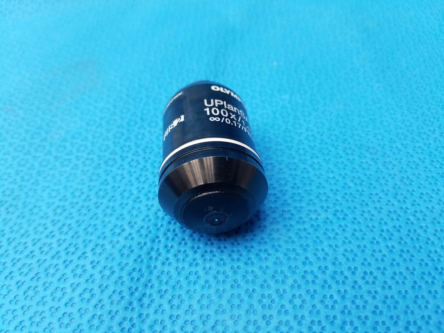 Black olympus uplanapo 100x microscope objective lens with metallic ring and high numerical aperture for oil use