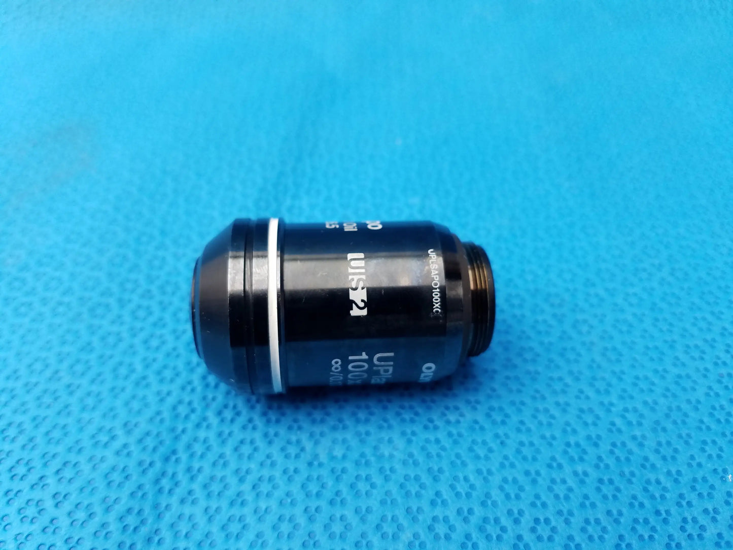 Black Olympus UPlanSApo 100x microscope objective lens with silver ring and high numerical aperture for oil use
