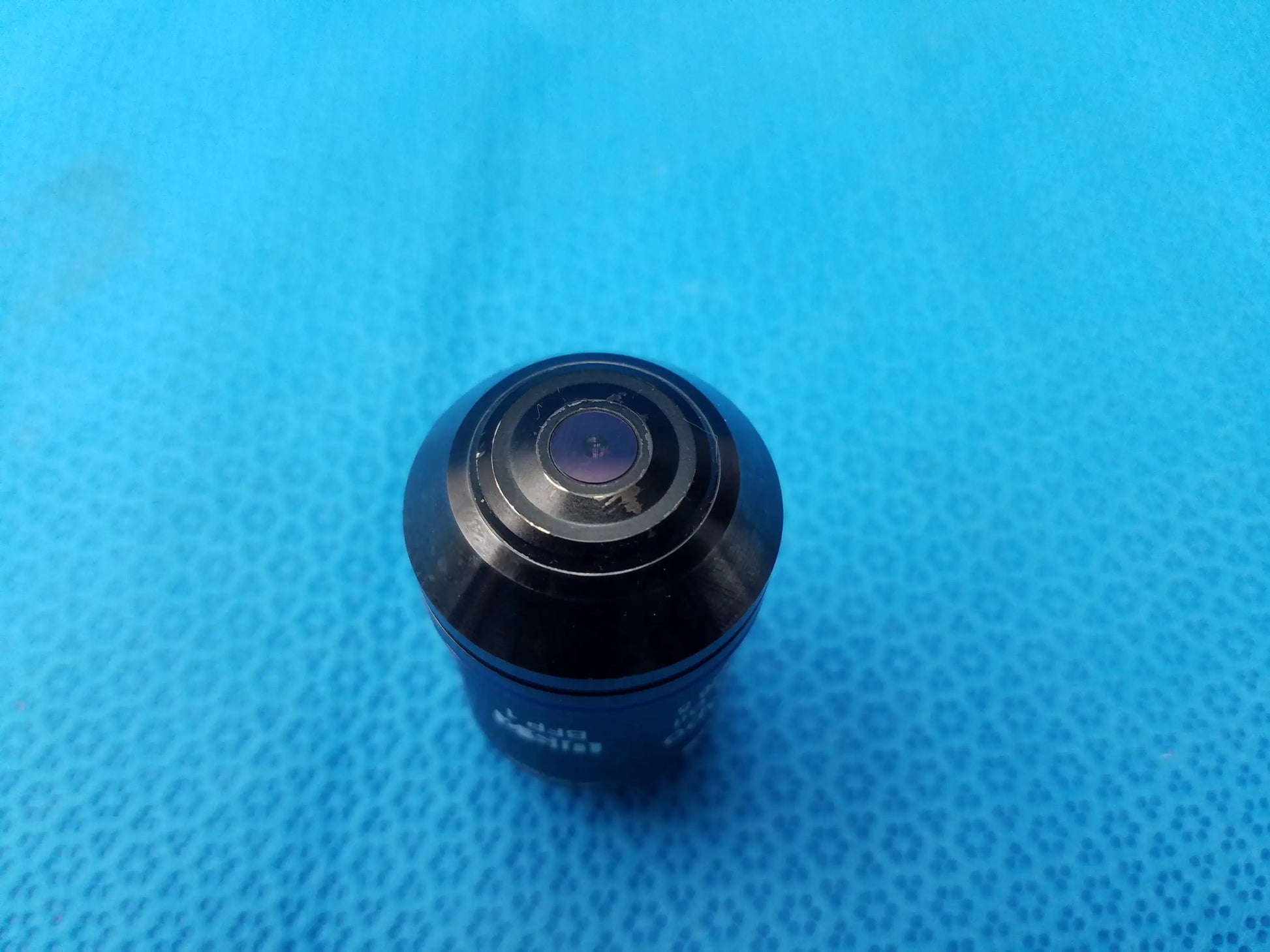 Black glossy Olympus UPlanSApo 60x microscope objective with concentric rings featuring numerical aperture 1.35 and field number 26.5