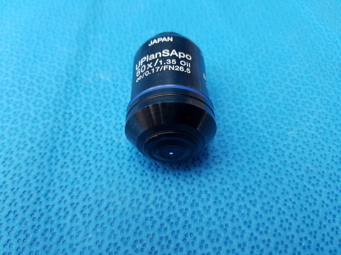 Black Olympus UPlanSApo 60x/1.35 microscope objective lens with blue ring featuring high numerical aperture and FN26.5 field number