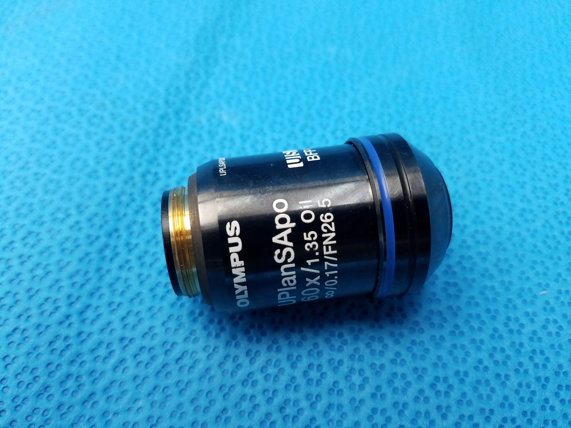Black Olympus UPlanSApo 60x oil immersion microscope objective lens with gold threading, blue ring, numerical aperture 1.35, FN26.5 field number